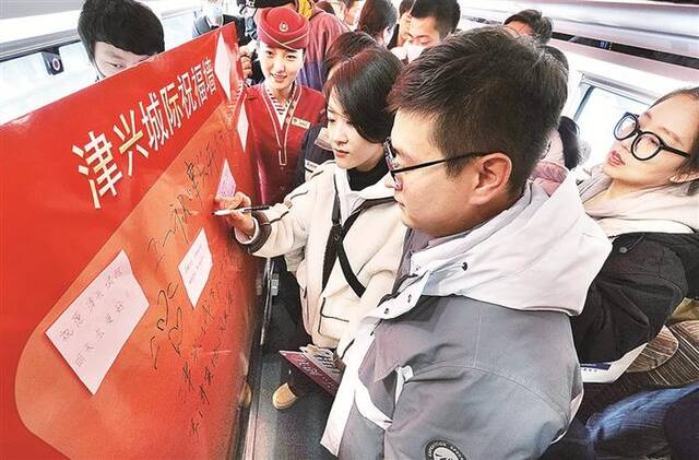12月18日，津兴城际铁路开通运营。乘坐首趟G8842次列车的旅客进行签字打卡留念。图片来源：视觉中国