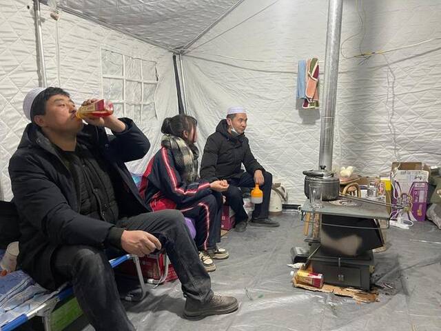 12月19日，马黑麦（前）和家人在帐篷里休息。