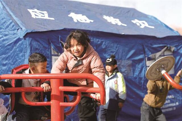 图为12月20日，在大河村安置点，小朋友在帐篷外做游戏。新华社记者方欣摄