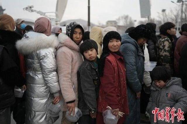 12月20日下午，甘肃省临夏州积石山县大河家镇一处安置点，等待领饭的受灾村民。