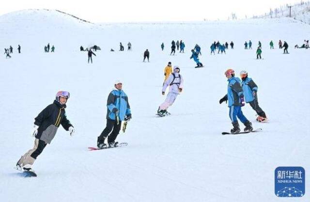 ↑12月21日，游客在那拉提国际滑雪场滑雪。