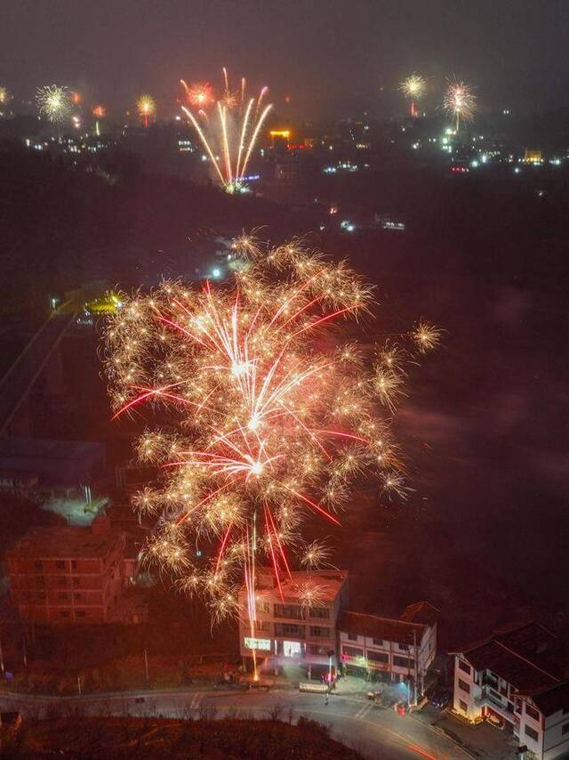 1月21日除夕夜，人们在贵州省毕节市赫章县平山镇对江社区燃放烟花（无人机照片）。新华社发（韩贤普摄）