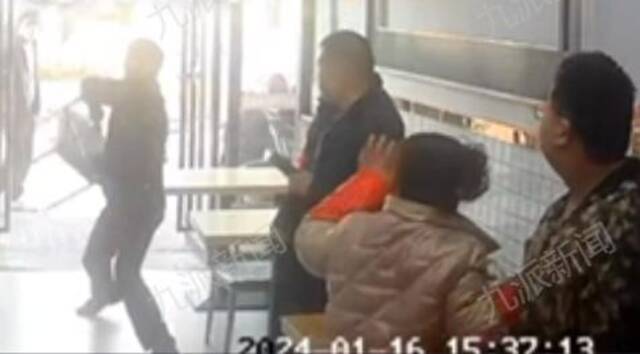 公职人员用凳子砸向店主。图/视频截图