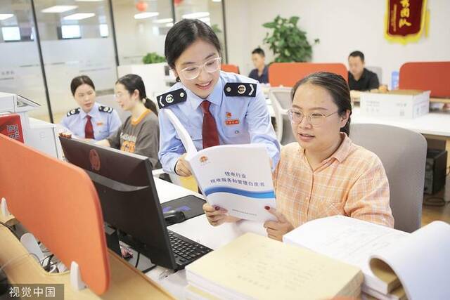 江西税务局党员干部正在帮助解答实际问题图片来源：视觉中国