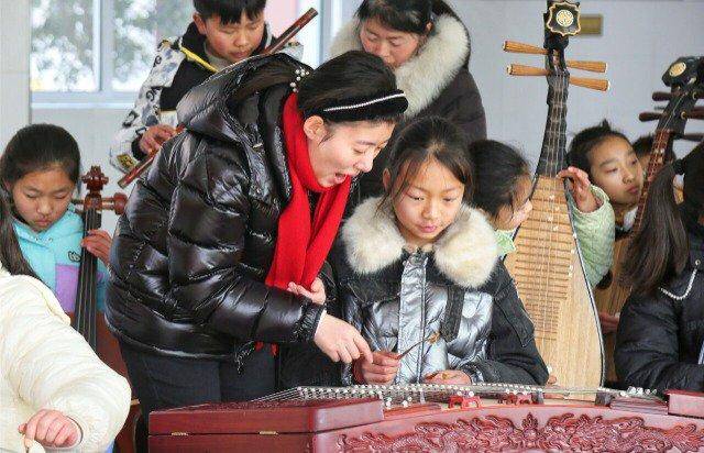 志愿者老师在指导学生学习乐器周强摄