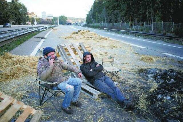 1月30日，法国南部普罗旺斯，农民们将拖拉机和干草堆停放在通往巴黎的高速公路上，设置路障并过夜。（视觉中国）