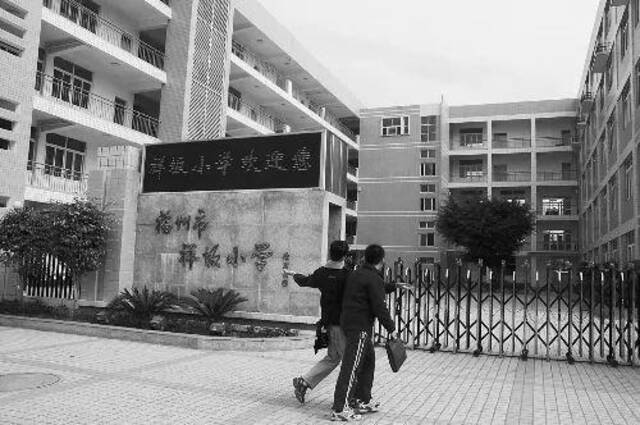 ·2010年1月，两名学生在福州祥坂小学门前玩耍。