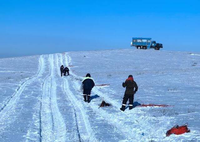 物探队员在雪地中收集电缆和检波器。