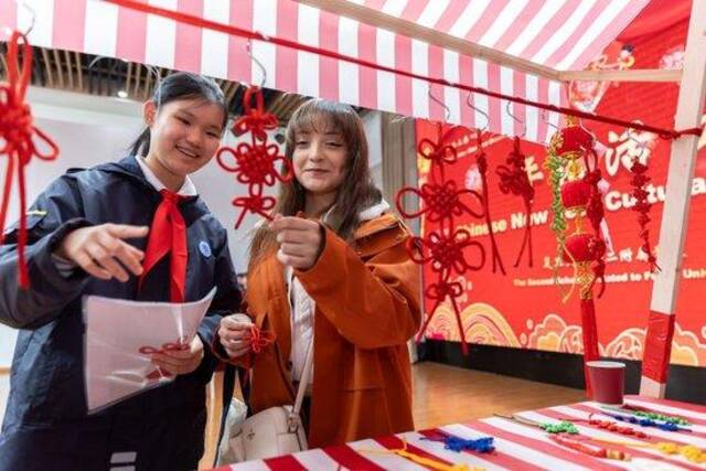 1月28日，复旦大学第二附属学校学生（左）为马斯卡廷学生（右）介绍中国结。