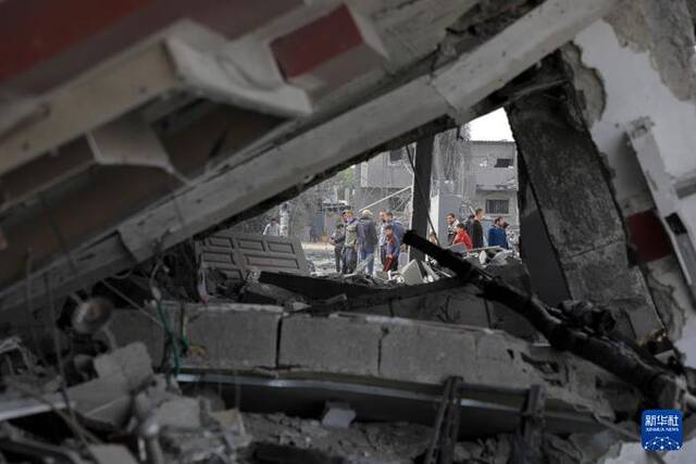 2月12日，人们在加沙地带南部城市拉法查看建筑残骸。图源：新华社
