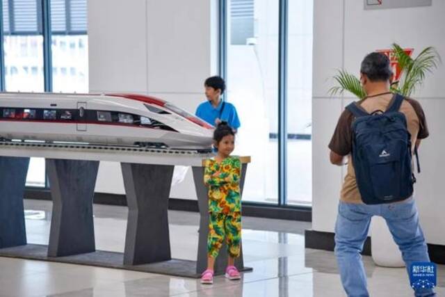1月24日，在印度尼西亚雅加达哈利姆站候车大厅，一名小朋友和雅万高铁高速动车组模型合影图：新华社