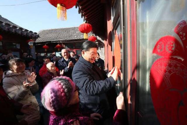 2019年2月1日上午，习近平在北京前门东区草厂四条胡同32号院，高兴地拿起一幅“福”字，亲自贴到门上，给这里的老街坊们拜年。新华社记者鞠鹏摄