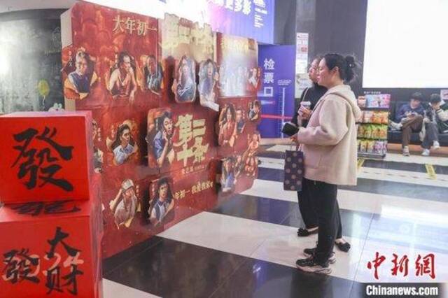   图为江西赣州一电影院摆放的春节档相关电影宣传物料吸引民众观看。刘力鑫摄