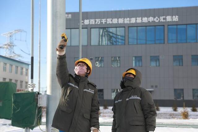 华能上都风电基地中心汇集站运行人员检查测量升压站设备温度，保障设备冬季正常运行。