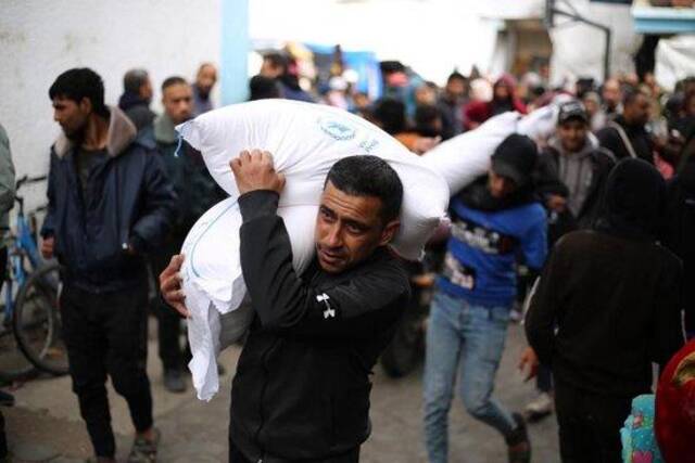 1月28日，在加沙地带南部城市拉法，人们领取联合国近东救济工程处提供的救助物资。新华社发（哈立德·奥马尔摄）