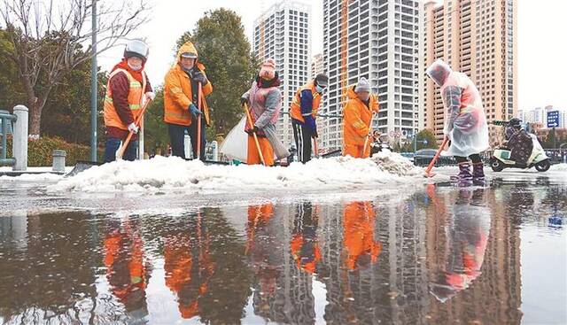 在江苏省连云港市海州区巨龙路，环卫工人清除积雪。新华社发(耿玉和摄)