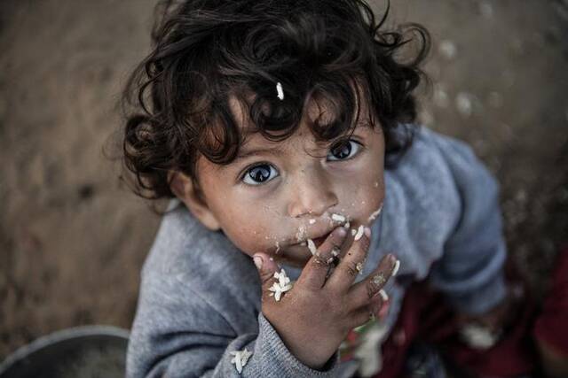 当地时间2024年2月22日，加沙地带拉法，一个孩子正在吃东西。视觉中国资料图