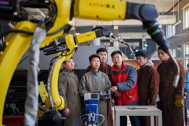 在河北兴隆县职教中心，学生在进行机器人焊接实训。新华社资料图