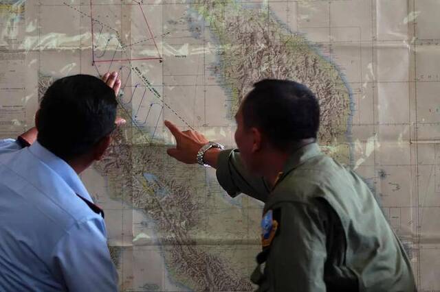 ▲当地时间2014年3月12日，印尼棉兰，印尼空军官员在军事基地绘图，继续搜寻失踪的马来西亚航空公司MH370航班 图源/视觉中国