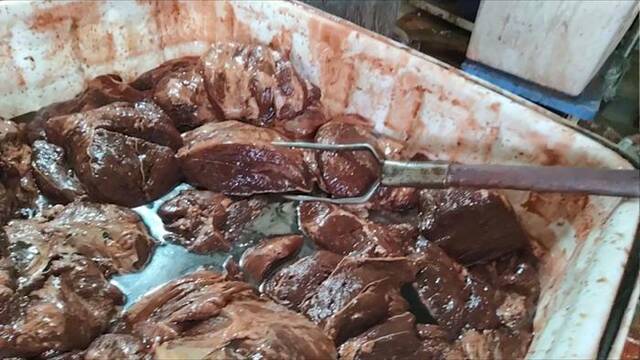 长丰镇西杨屯村一家煮肉作坊内，工人正在腌制假驴肉，其原料多为母猪前腿肉。新京报记者韩福涛摄