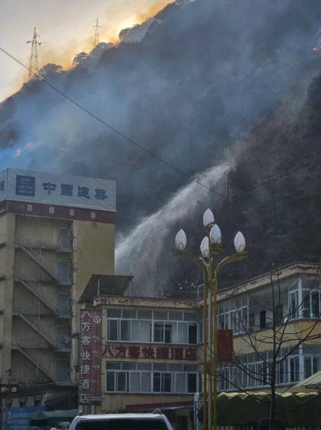 在距离雅江县城四五公里处可以看见明火，还有消防队员在喷射水枪灭火。上游新闻记者李文滔摄