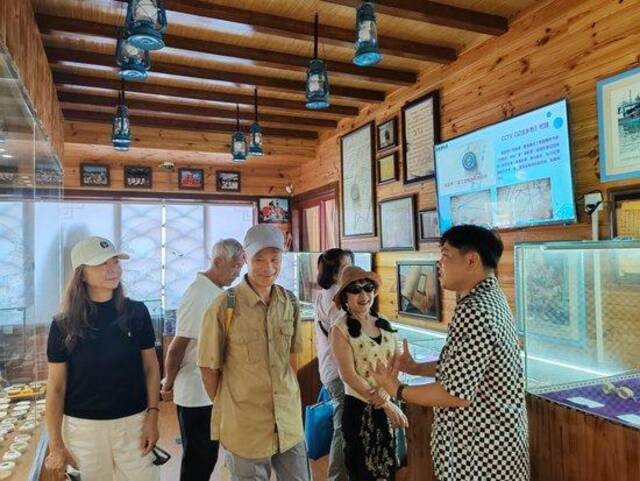 在潭门镇排港村更路簿博物馆，馆长王振忠正在为游客讲述潭门老渔民的故事。新华社记者夏天摄