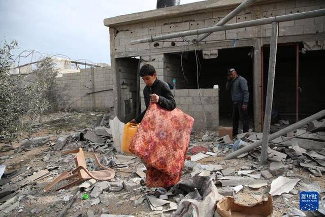3月26日，在加沙地带南部城市拉法，人们在废墟中收集物品。新华社发（哈立德·奥马尔摄）