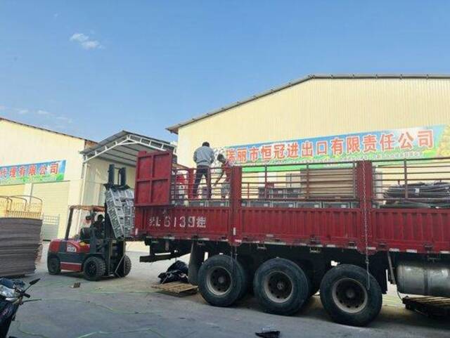 在瑞丽大道旁，四名缅甸搬运工正在用叉车填满杨建荣的一辆大货车。装满一辆货车，他们能得到约1200元的报酬。图/南方周末记者顾月冰