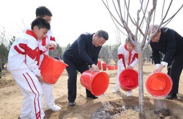 △2024年4月3日，习近平总书记同少先队员一起给刚栽下的树苗浇水。