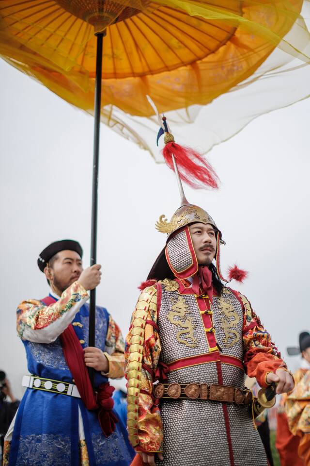 当日的仪式中，“皇帝”身穿金色盔甲，盔甲两侧还有金色龙纹，完整复刻了《出警入跸图》中的衣着模样。新京报记者王子诚摄