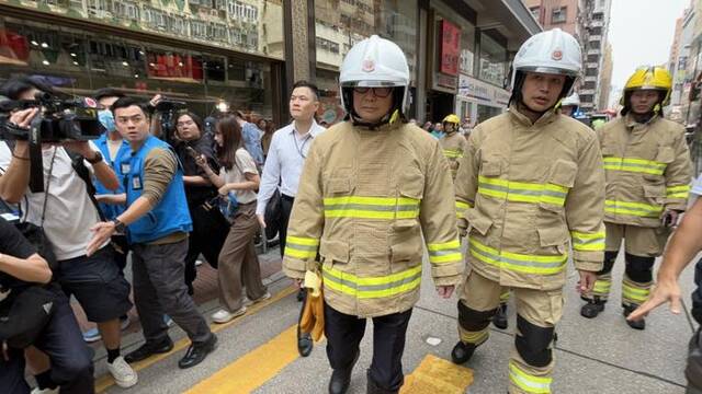 邓炳强（左）穿消防制服赴火灾现场视察救援工作。图自香港星岛网