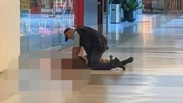 一名警察在涉事购物中心查看伤者图自澳大利亚新闻网报道配图