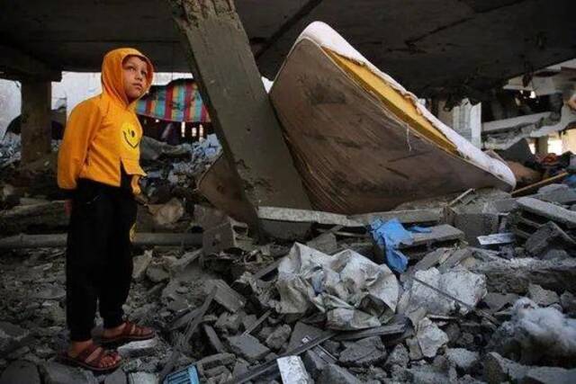 4月17日，在加沙南部城市拉法，男孩站在遭以军空袭的住宅废墟上图：新华社
