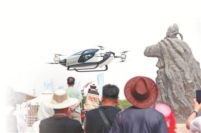 宁夏回族自治区中卫市，游客正在观赏飞行汽车飞越黄河。中新社记者于晶摄