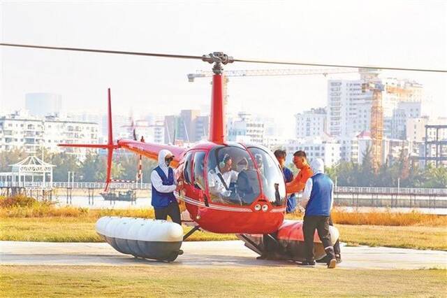 海南省三亚市凤凰岛，游客正准备搭乘直升机进行低空游。图片来源：视觉中国