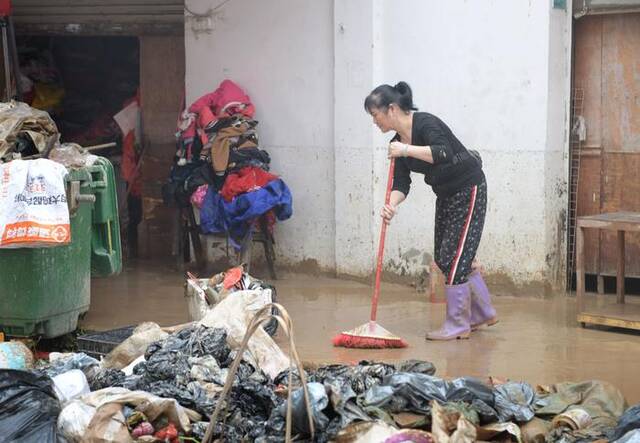 4月21日，洪水过后，广东省韶关市武江区龙归镇的居民在清理路面。新华社记者卢汉欣摄
