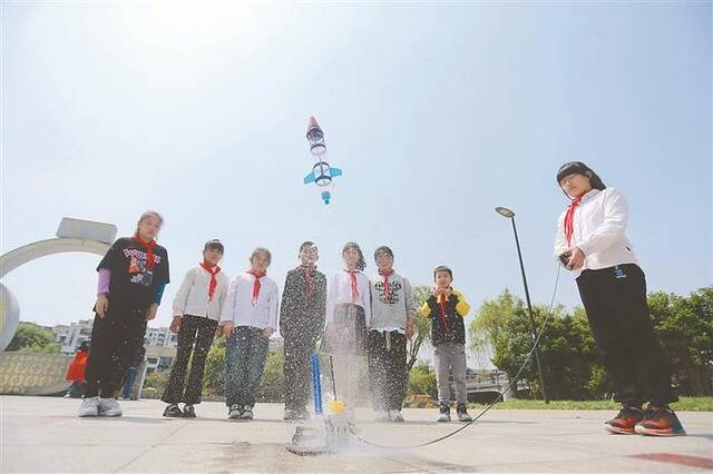 4月22日，江苏省扬州市广陵区何园社区，志愿者在教学生制作航天小模型。图片来源：视觉中国