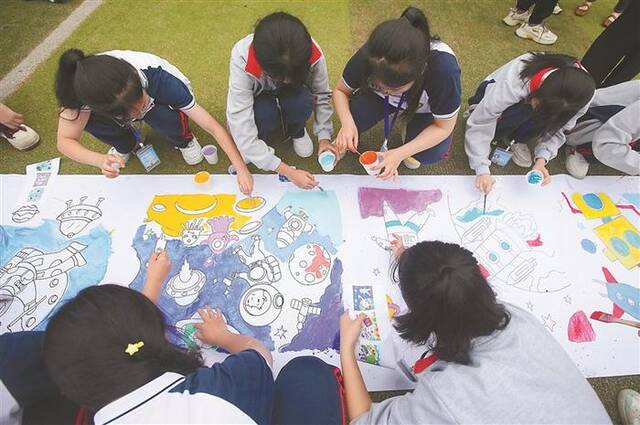 日前，广西壮族自治区柳州市融水苗族自治县保桓中学，孩子们在进行航天画卷涂鸦。图片来源：视觉中国