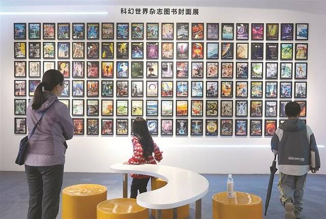 4月27日，观众在“首都青少年科幻教育空间”主题展览上参观科幻世界杂志图书封面。图片来源：视觉中国