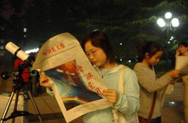 2007年10月24日，北京航空航天大学一名学生在翻看《中国航天报》号外。新华社记者罗晓光摄