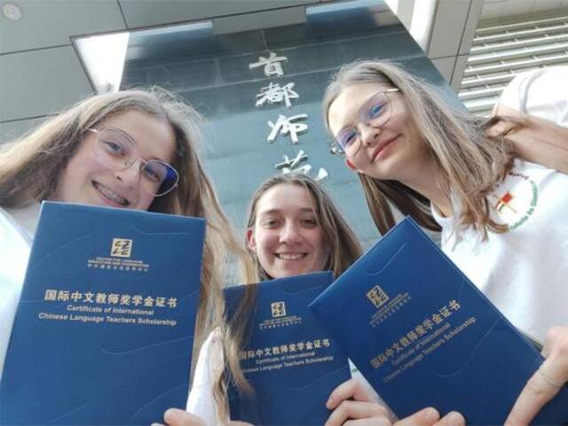 匈牙利学生王米丽（左）、胡灵月（中）、宋智孝（右）手持国际中文教师奖学金证书在首都师范大学合影。（受访者供图）