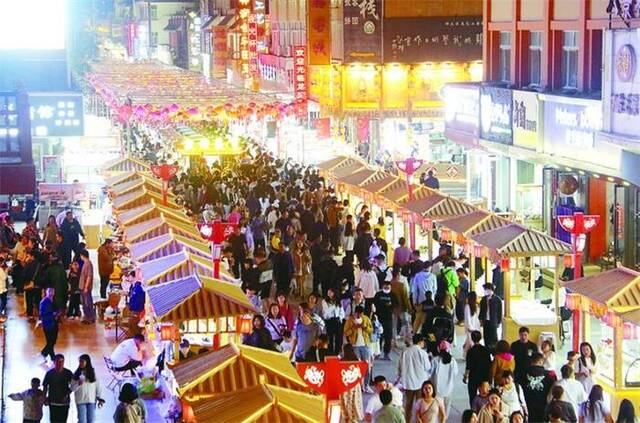 图为游客在甘肃省敦煌市游览夜市。新华社发（张晓亮摄）