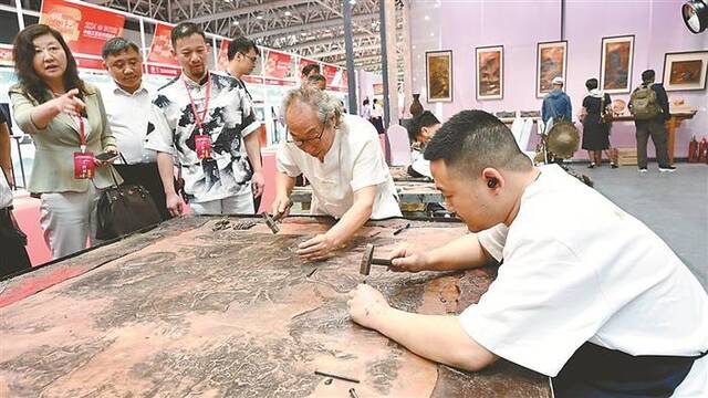 近日，第四届中国工艺美术博览会在福建福州开幕，图为铜饰手工艺人现场展示技艺。