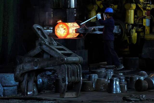 2024年4月26日，印度西孟加拉邦，一名钢厂工人搬运锻造好的钢材图片来源：路透社