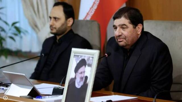 ·5月20日，会议上的穆赫贝尔（右）。他面前摆放着已故伊朗总统莱希的照片。