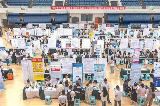 近日，郑州大学举办校园招聘会活动，求职投递简历的大学生络绎不绝。图片来源：视觉中国