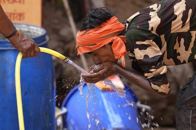 5月27日，印度一名工人在炎热的夏日喝水。