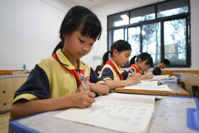 5月30日，学生在之江小学“留守儿童之家”写作业。
