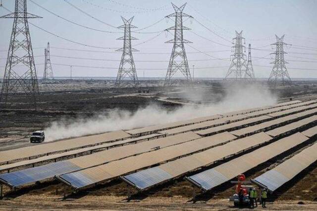 当地时间2024年1月12日，印度古吉拉特邦，在阿达尼集团拥有的Khavda可再生能源园区，工人们安装太阳能电池板。视觉中国资料图
