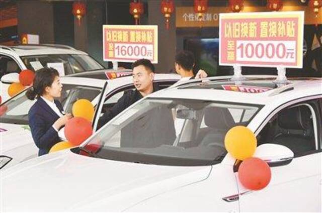 图为近日，在河北省邯郸市永年区汽车促销活动上，消费者正在选购以旧换新优惠的汽车。图片来源：视觉中国